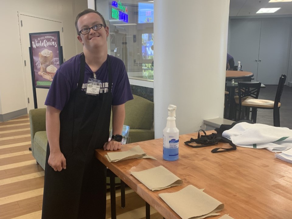 Student on the job cleaning and folding napkins.